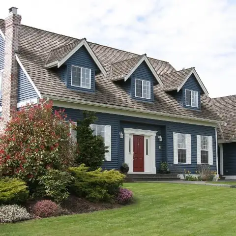 Blue suburban home with freshly manicured lawn - Keep pests away from your home with Inman-Murphy, Inc.